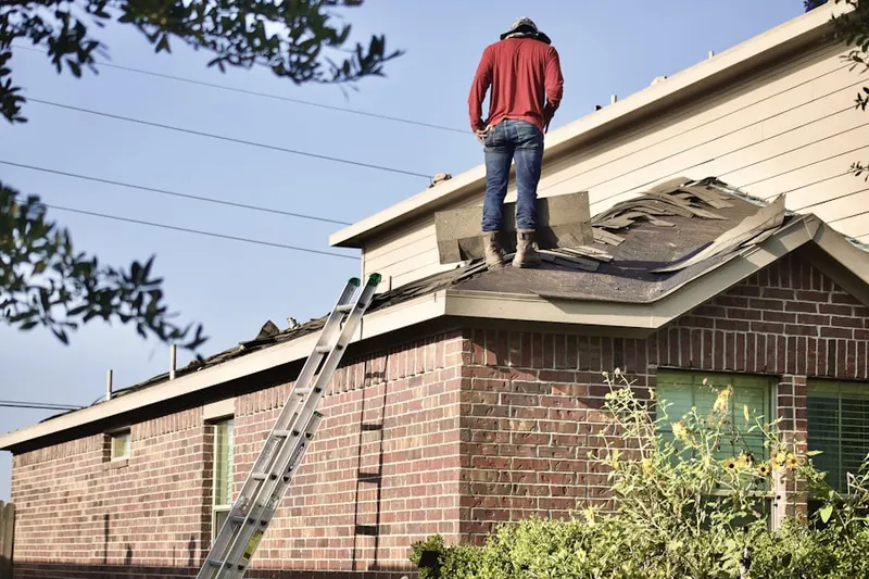 Professional roofer working on a residential roof in Blooming
